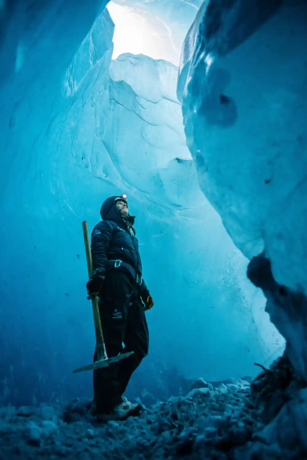 Diver in wetsuit exploring underwater ice cave