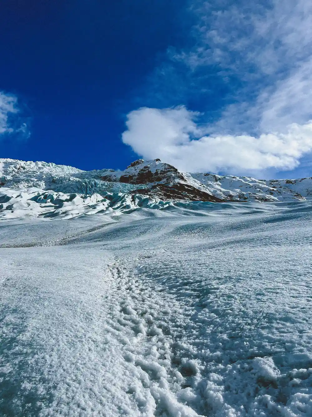 Expansive glacier landscape with mountains under blue sky