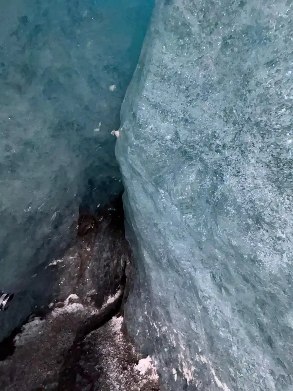 Four people in colorful jackets in ice crevasse