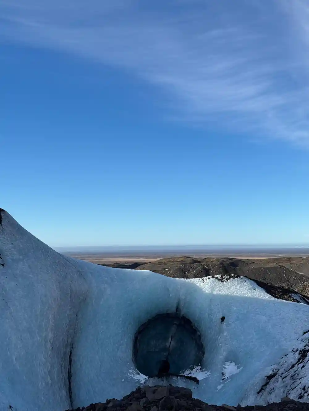 Glacier landscape with coastal flatlands visible in background