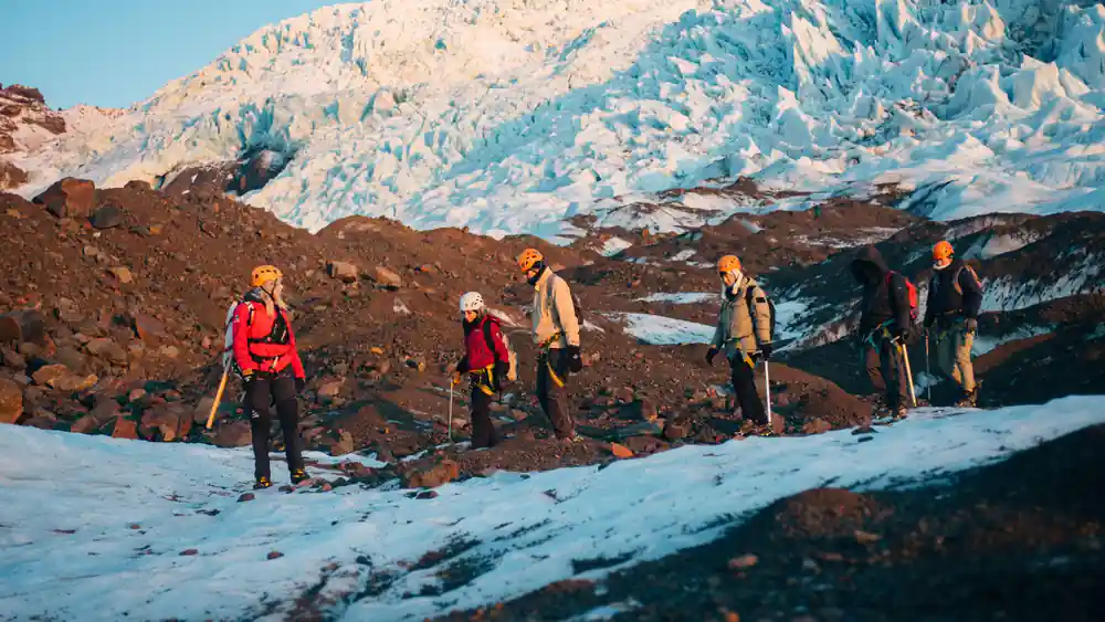 Group of hikers on rocky terrain near glacier