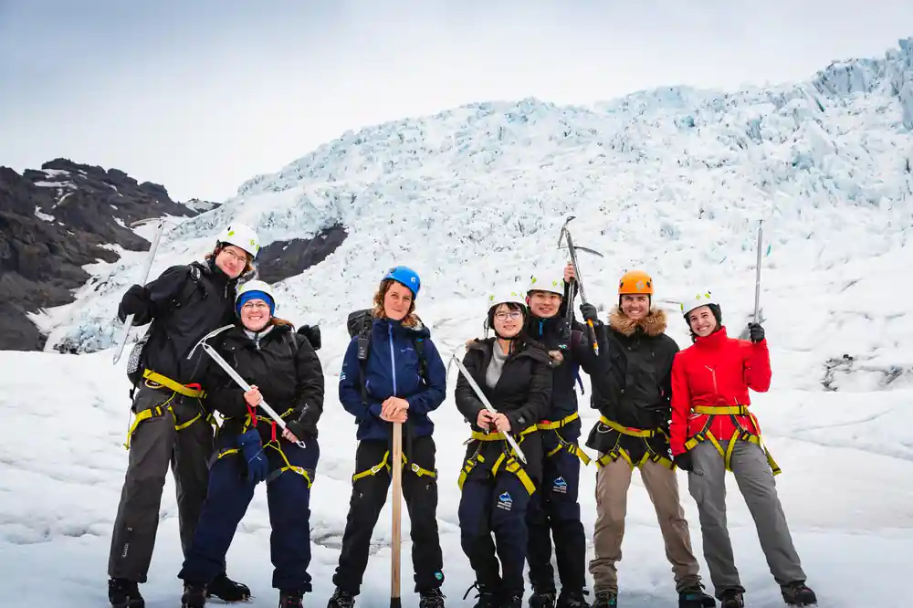 Group of people in helmets on snowy glacier