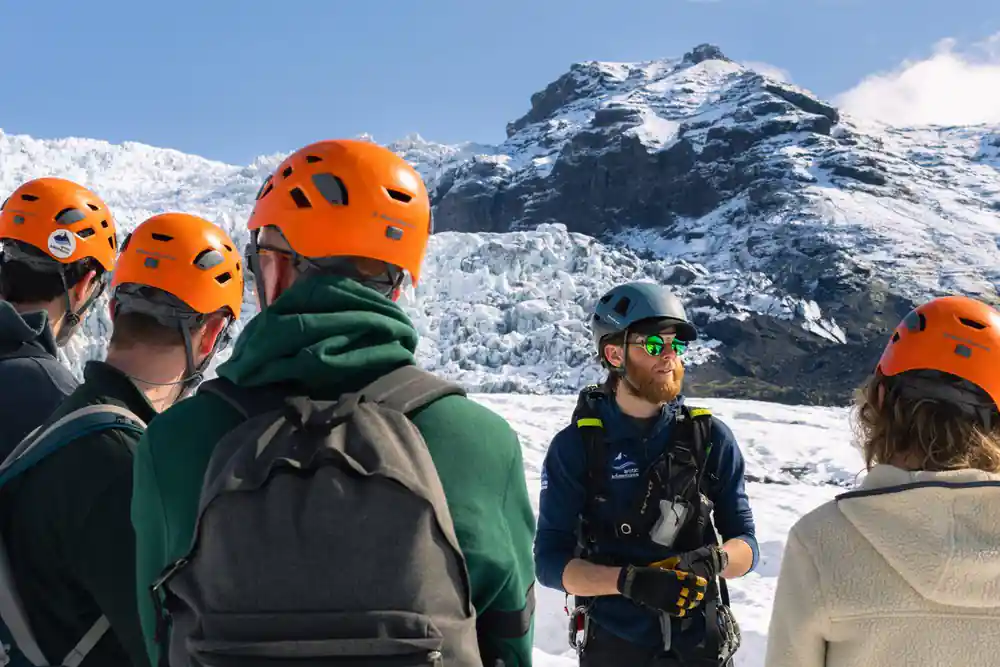 Group wearing orange helmets on snowy ground