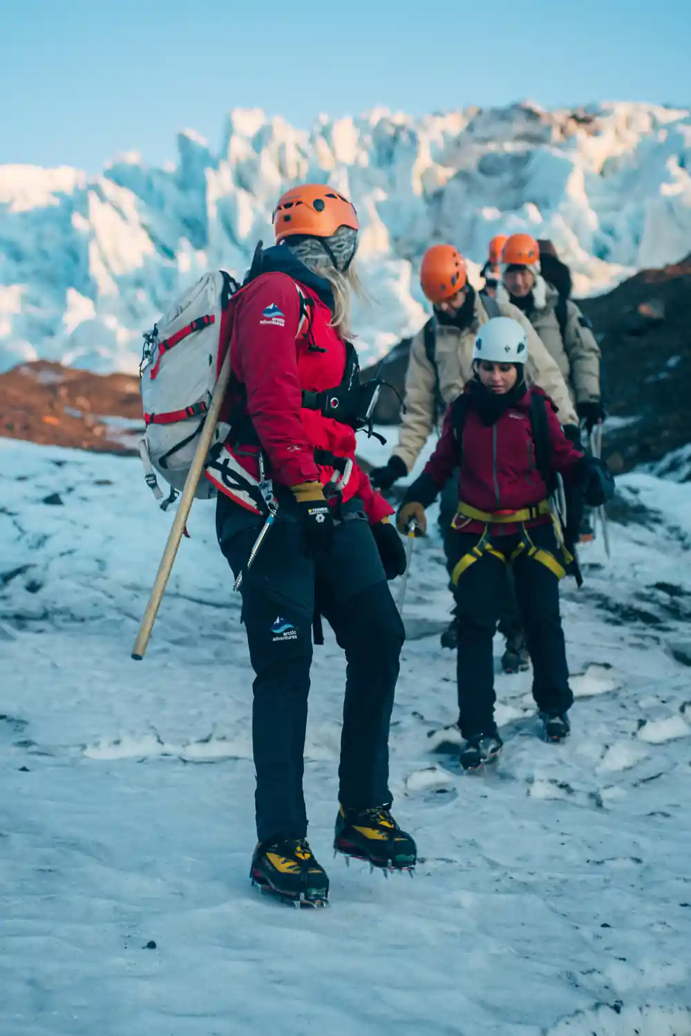 Person with backpack hiking on snowy glacier