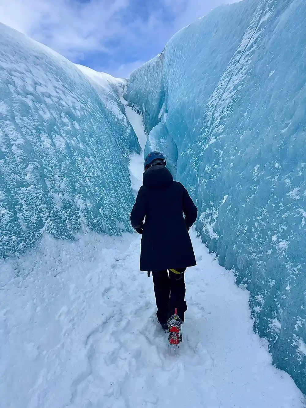 Runner jogging through ice canyon in winter gear
