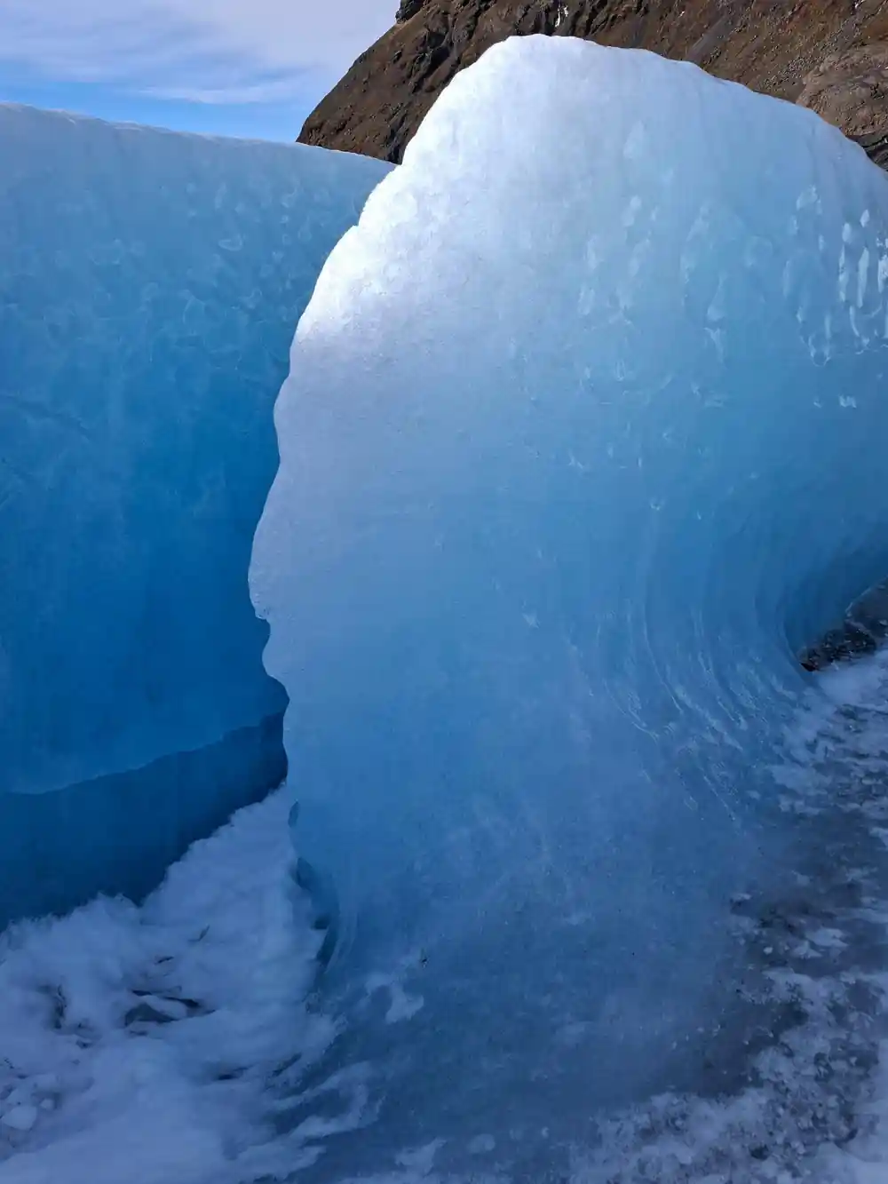 Tall ice arch formation with rock arch above